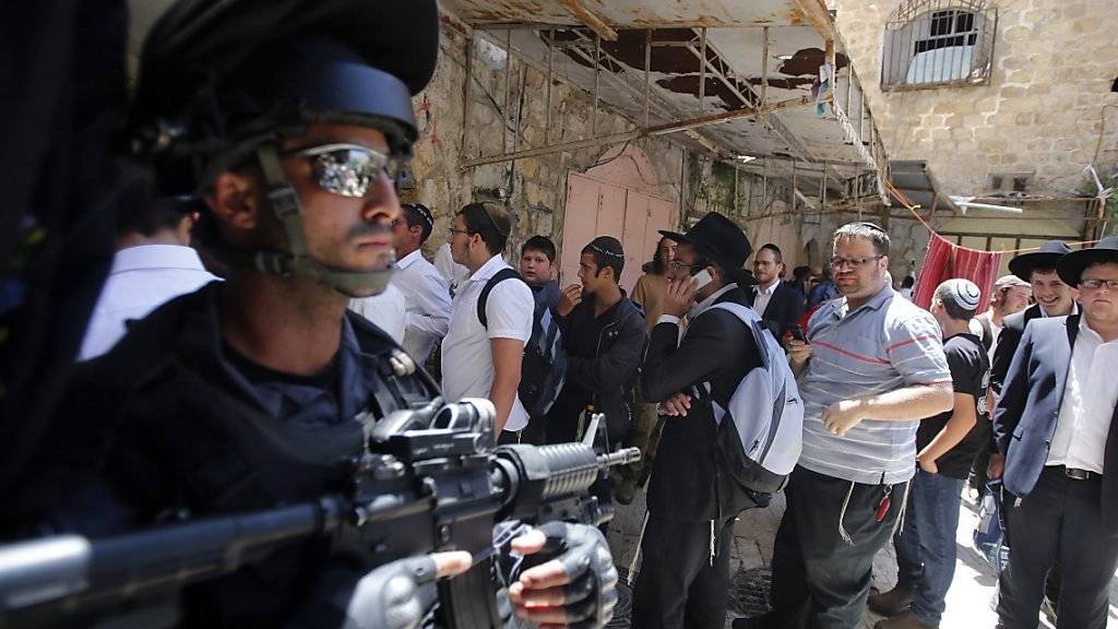 Ein israelischer Grenzpolizist steht bewaffnet vor der Klagemauer: Der traditionelle Priestersegen lockt Tausende Gläubige nach Jerusalem.