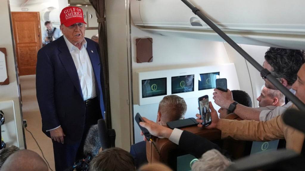 US-Präsident Donald Trump (M) spricht mit Reportern in der Air Force One auf dem Rückflug zur Joint Base Andrew, nachdem er ein Gefangenenlager für Migranten in Ochopee, Florida besucht hat. Foto: Evan Vucci/AP/dpa