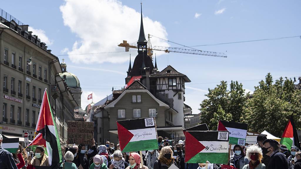 Personen protestieren am Samstag in Bern bei einer Kundgebung gegen die Unruhen in Nahost und plädieren für Frieden in Palästina.