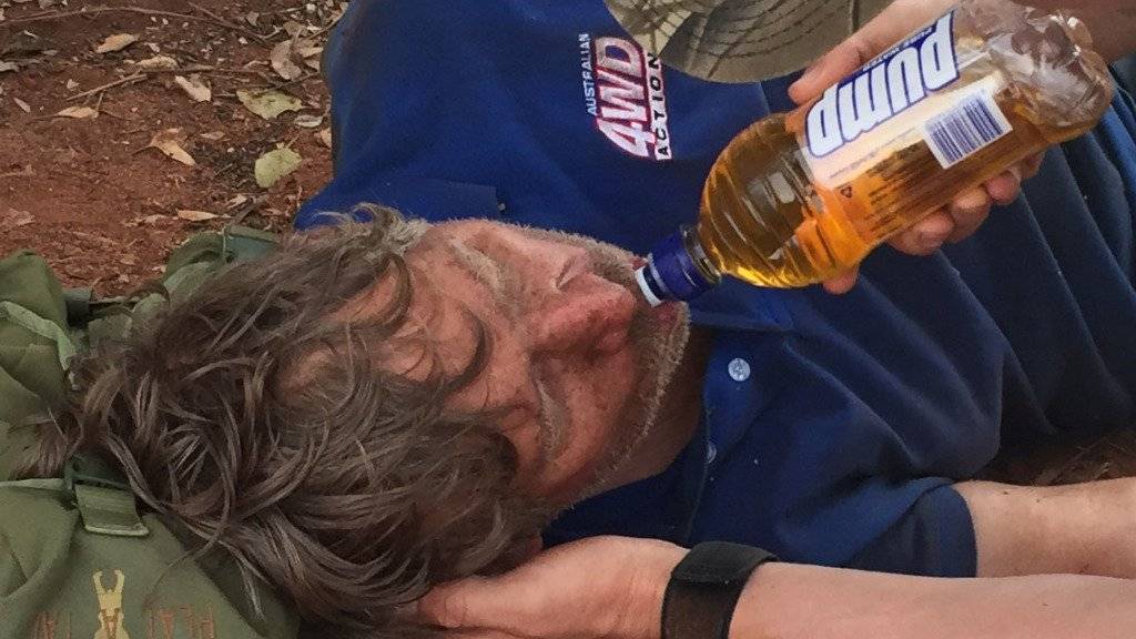 Nach Tagen im australischen Busch wird ein Australier völlig dehydriert gerettet. Ein Retter gibt dem 62-Jährigen zu Trinken.