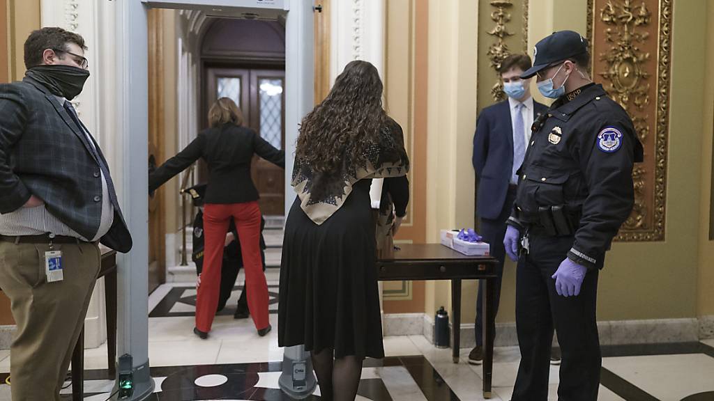 Kongressmitarbeiter gehen durch einen Metalldetektor und Sicherheitskontrolle, bevor sie die Kammer des Repräsentantenhauses betreten. Foto: J. Scott Applewhite/AP/dpa