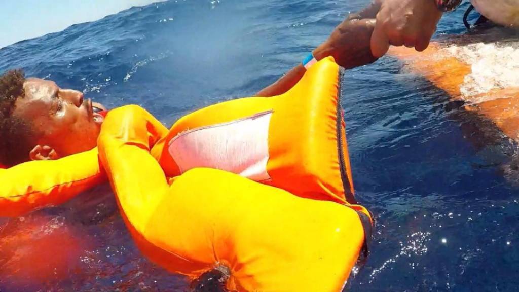 Ein Migrant aus Afrika wird von der italienischen Küstenwache aus dem Mittelmeer gerettet. (Archivbild)