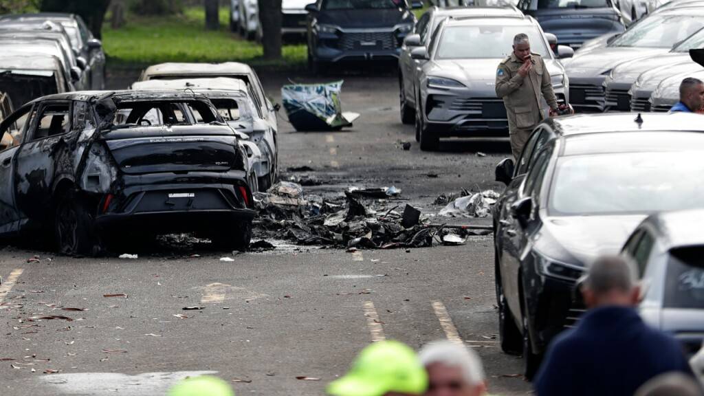 dpatopbilder - Ausgebrannte Fahrzeuge und Trümmer sind zu sehen, nachdem zwei Hubschrauber Berichten zufolge in der Luft zusammengestoßen und auf den Parkplatz eines Autohauses in Rio de Janeiro gestürzt sind. Foto: Bruna Prado/AP/dpa