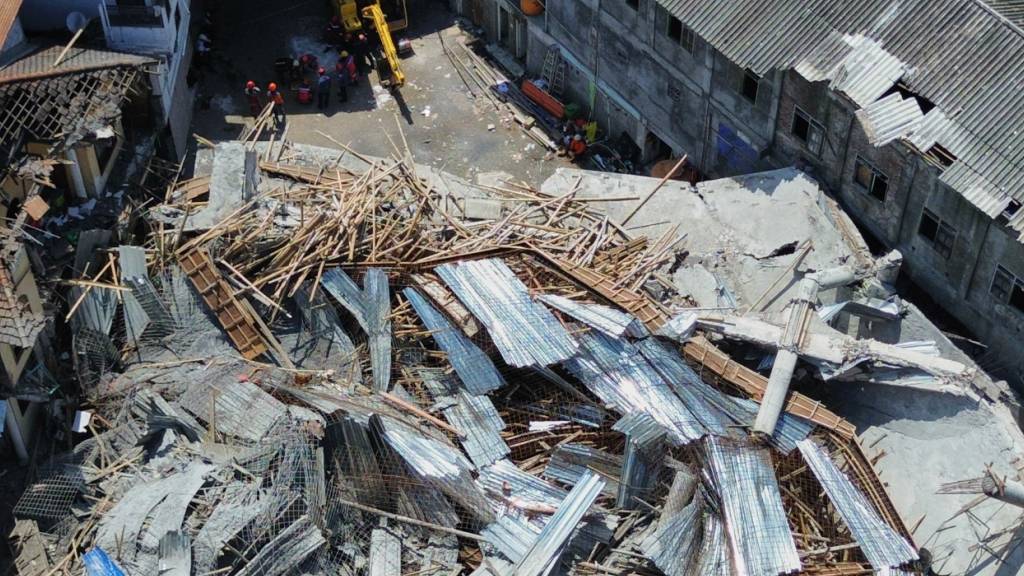 dpatopbilder - Diese Luftaufnahme einer Drohne zeigt, wie Retter nach Opfern suchen, die nach dem Einsturz eines im Bau befindlichen Gebäudes in einem islamischen Internat unter den Trümmern verschüttet wurden. Foto: Trisnadi/AP/dpa