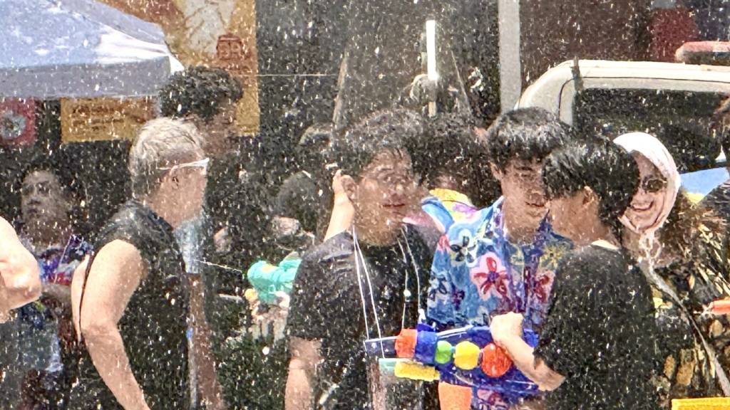 Menschen nehmen auf der Silom Road in Bangkok an einer Wasserschlacht teil. Foto: Carola Frentzen/dpa