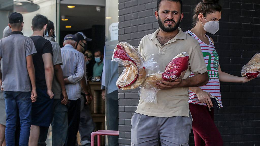 Menschen verlassen eine örtliche Bäckerei, nachdem sie inmitten der schweren Treibstoffknappheit und der Stromausfälle, die das Land inmitten einer der schlimmsten Wirtschaftskrisen der letzten Zeit lähmen, eine Packung Brot geholt haben. Foto: Marwan Naamani/dpa