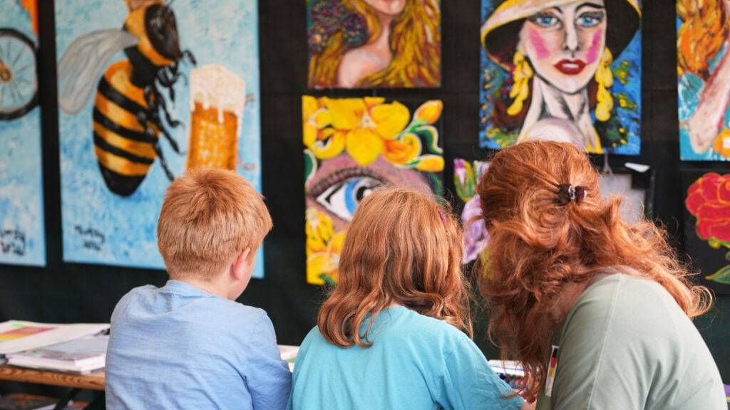 Eine Familie nimmt an einem Malworkshop während des Red Head Days Festivals in Tilburg teil. Foto: Virginia Mayo/AP/dpa