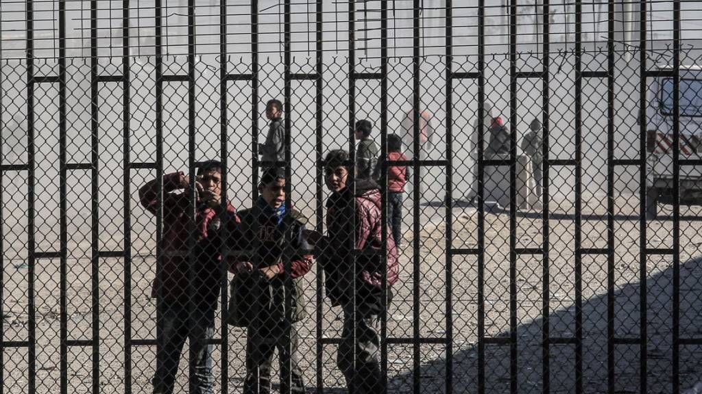 dpatopbilder - Palästinensische Kinder stehen hinter einem Zaun in der Nähe des Grenzübergangs Kerem Shalom, über den Lastwagen mit internationalen Hilfsgütern in den Gazastreifen einfuhren. Foto: Abed Rahim Khatib/dpa