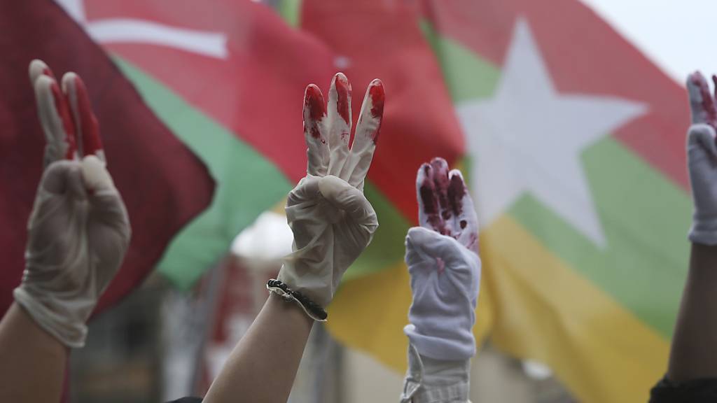 Myanmarische Demonstranten die in Taiwan leben, tragen rot bemalte Handschuhe und zeigen den symbolischen Drei-Finger-GruSS bei einem Protest gegen das Militärregime in Myanmar.(Symbolbild)