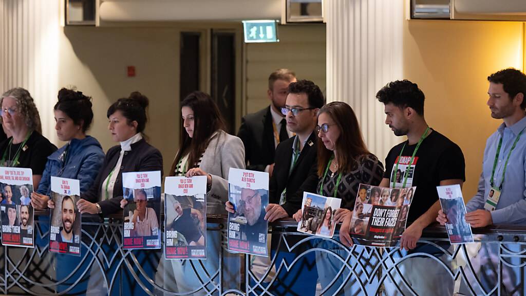 ARCHIV - Angehörige zeigen während der Rede von Izchak Herzog, Präsident von Israel, auf der 60. Münchner Sicherheitskonferenz Plakate mit Fotos von Geiseln der Hamas und der Aufschrift «Bring them Home now!». Foto: Sven Hoppe/dpa