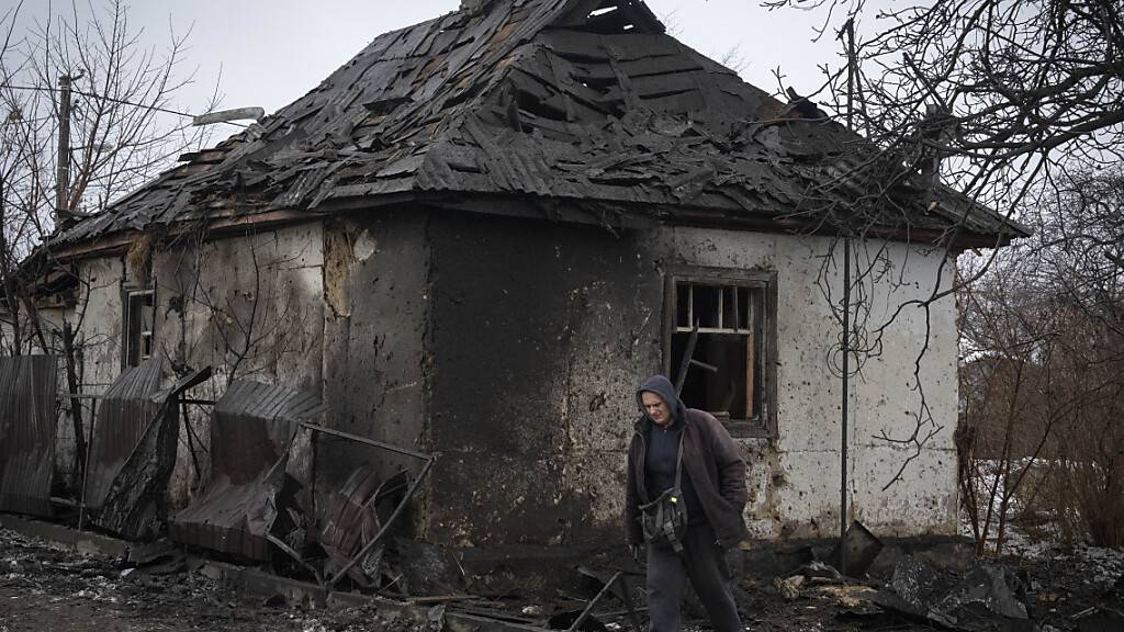 dpatopbilder - Ein Anwohner geht an einem Haus vorbei, das von einem russischen Raketenangriff beschädigt wurde. Foto: Efrem Lukatsky/AP/dpa