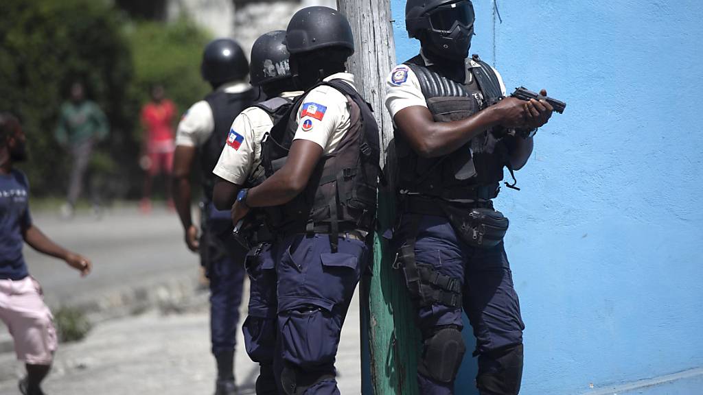 Polizisten mit gezogenen Waffen suchen in Port-au-Prince nach Verdächtigen im Mordfall des haitianischen Präsidenten Jovenel Moise. Foto: Joseph Odelyn/AP/dpa