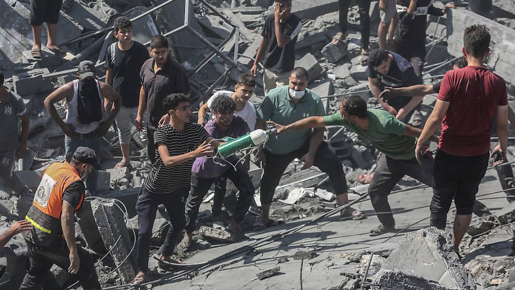 Palästinenser durchsuchen die Trümmer eines Gebäudes in Chan Yunis, das bei einem israelischen Luftangriff zerstört wurde. Foto: Mohammed Talatene/dpa