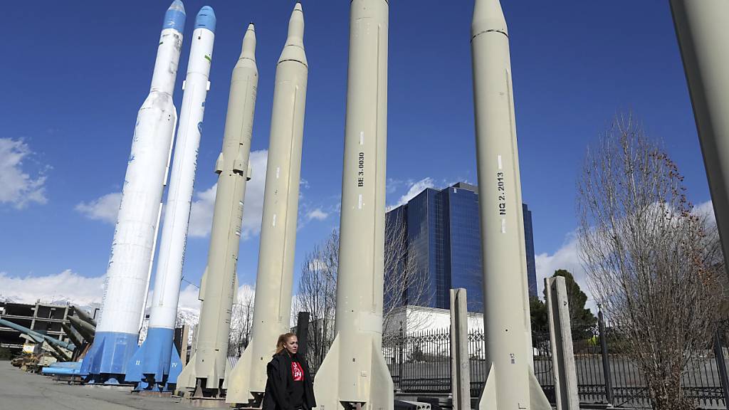 ARCHIV - Eine Frau geht in einem Erholungsgebiet im Norden Teherans an den im Iran produzierten Raketen und Satellitenträgern vorbei, die in einer Dauerausstellung gezeigt werden. Foto: Vahid Salemi/AP/dpa