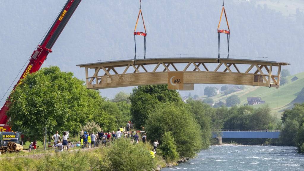 Die 35 Tonnen schwere Holzbrücke wird mit einem Kran an den neuen Ort gehievt, über die Engelbergeraa bei Büren zwischen Oberdorf und Dallenwil im Kanton Nidwalden.