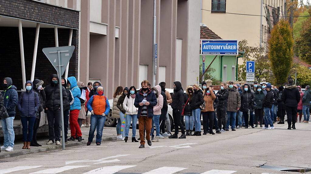 Zahlreiche Menschen mit Gesichtsmaske warten in einer Schlange, um sich auf das Coronavirus testen zu lassen. Foto: Edmund ÷rzsik/TASR/dpa
