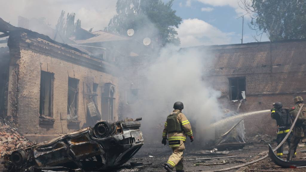 ARCHIV - Rettungskräfte löschen einen Brand in Saporischschja. Foto: Evgeniy Maloletka/AP/dpa/Archivbild