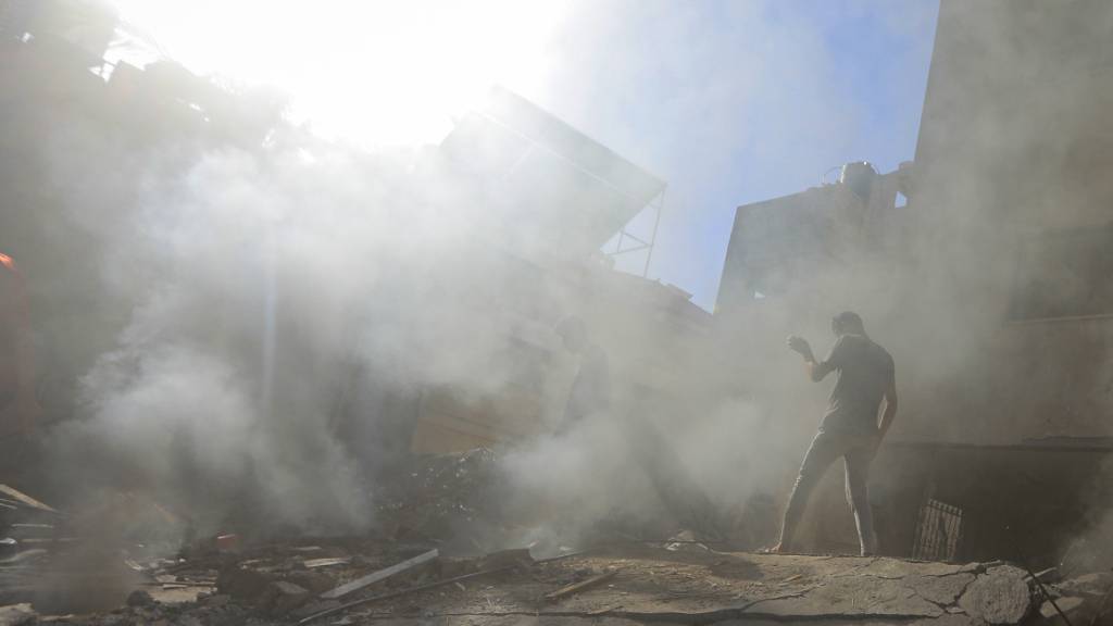 dpatopbilder - Palästinenser und Mitarbeiter des Zivilschutzes suchen in den Trümmern eines zerstörten Gebäudes nach einem israelischen Luftangriff auf Chan Junis nach Überlebenden. Foto: Mohammed Talatene/dpa