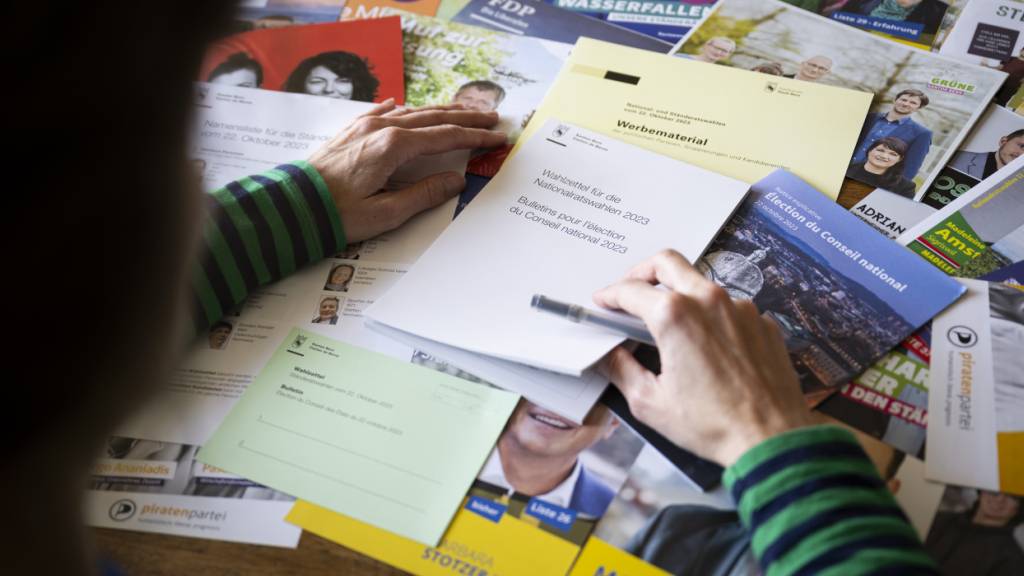 Eine Frau betrachtet das Wahlmaterial für die National- und Ständeratswahlen. (Symbolbild)