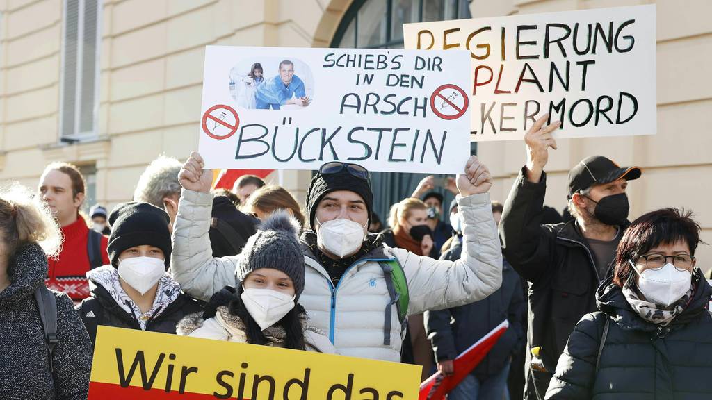 Demonstranten halten Schilder bei der Demonstration in Wien hoch.