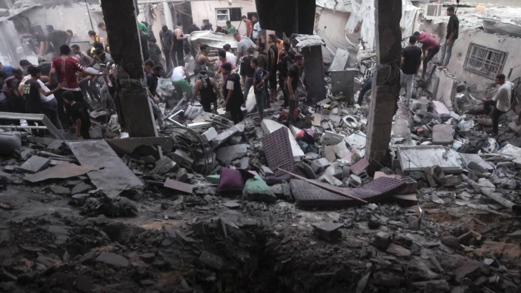 dpatopbilder - Palästinenser suchen unter den Trümmern eines zerstörten Hauses nach einem israelischen Luftangriff nach Überlebenden. Foto: Mohammed Dahman/AP/dpa