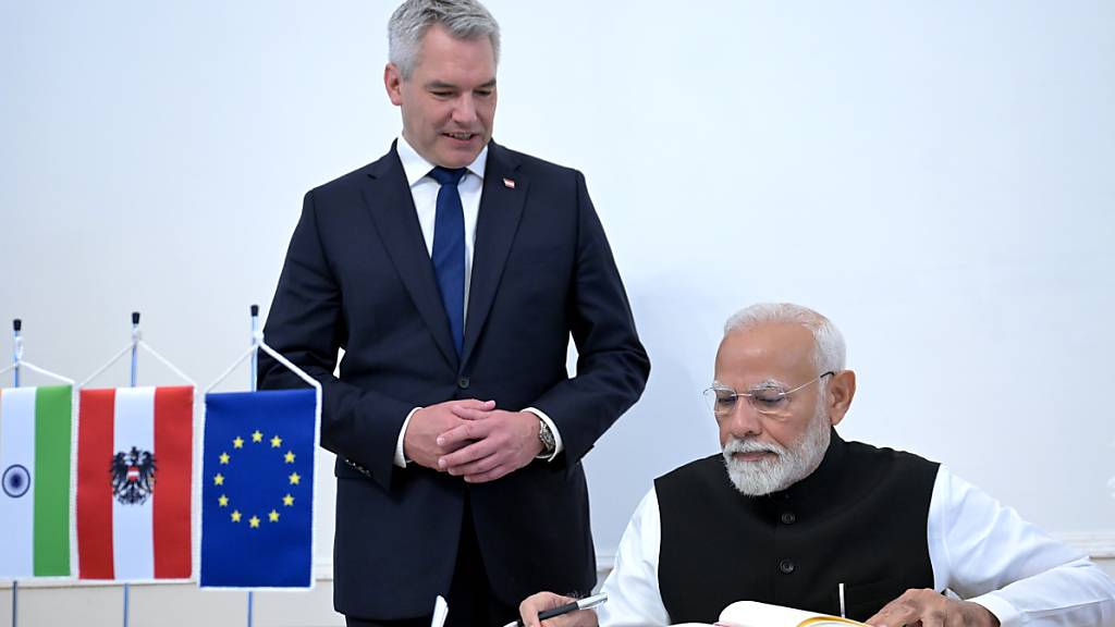 Der indische Premierminister Narendra Modi bei der Eintragung ins Gästebuch mit dem österreichischen Bundeskanzler Karl Nehammer. Foto: Roland Schlager/APA/dpa