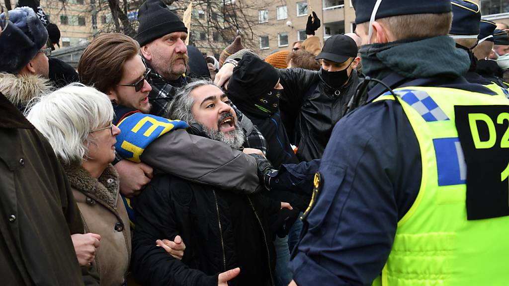 Menschen demonstrieren ohne Mund-Nasen-Schutz gegen die Corona-Beschränkungen des Landes und treffen auf Polizisten. Der Protest wurde von der Polizei wegen fehlender Genehmigung für die öffentliche Versammlung aufgelöst. Foto: Henrik Montgomery/TT NEWS AGENCY/dpa