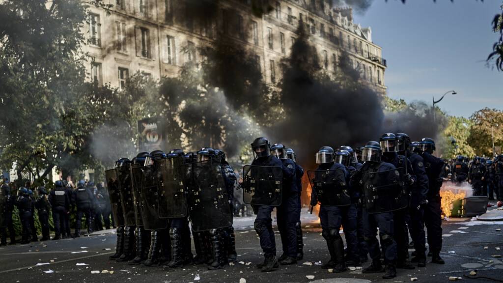 ARCHIV - Polizisten stehen bei Protesten gegen unterfinanzierte Schulen in Paris auf der Straße während hinter ihnen Mülltonnen brennen. Foto: Antonin Burat/Le Pictorium via ZUMA Press/dpa (Archivbild)