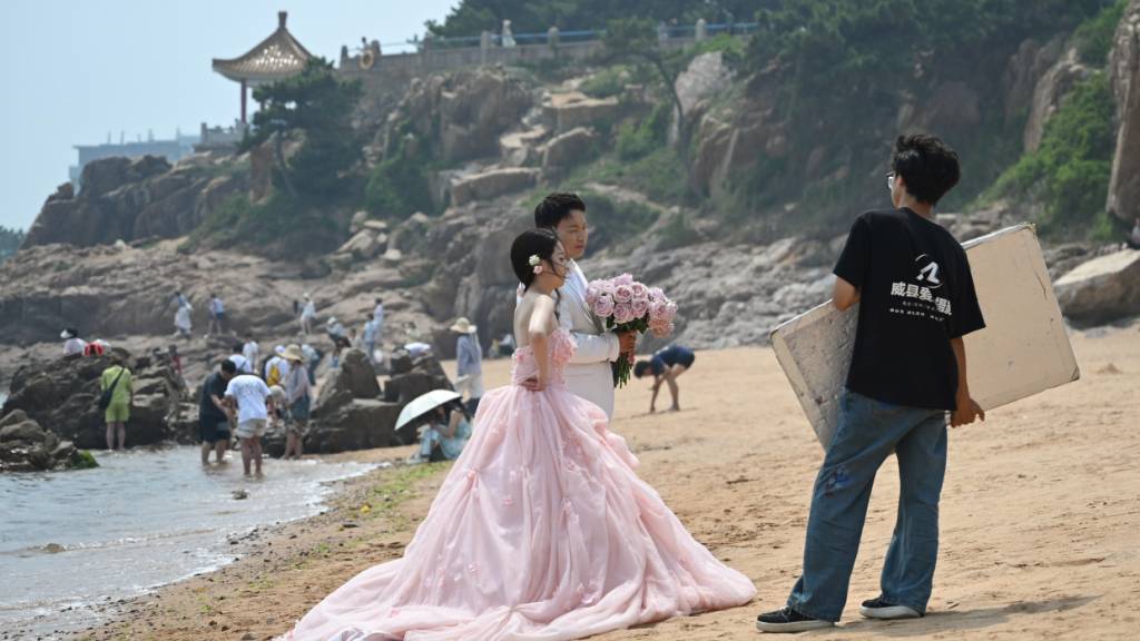 ARCHIV - Ein chinesisches Brautpaar posiert an einem Strand. Foto: Johannes Neudecker/dpa/Archivbild