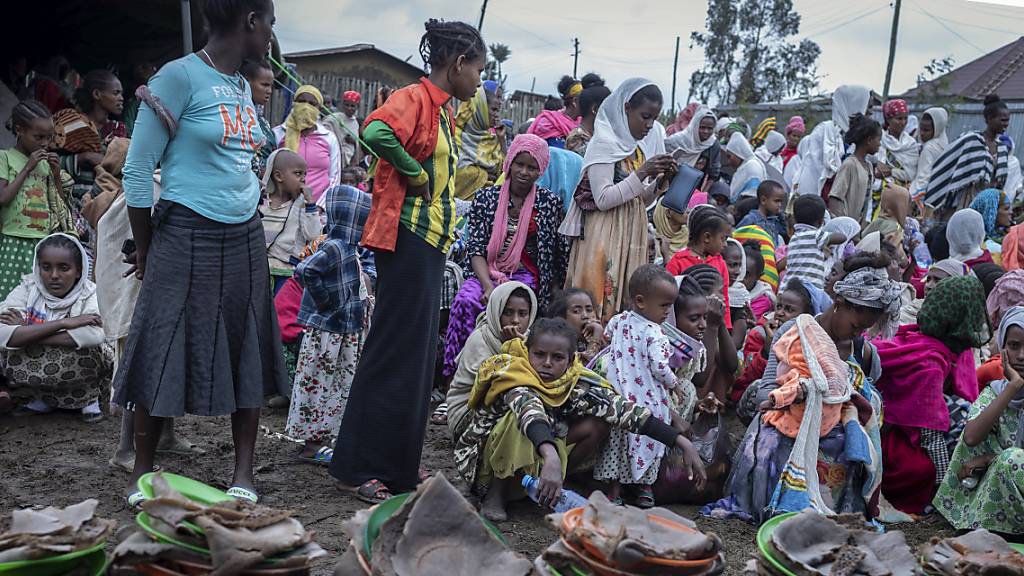 ARCHIV - Vertriebene Äthiopier aus verschiedenen Städten der Amhara-Region warten in einem Zentrum für Binnenvertriebene auf die Verteilung von Hilfsgütern. Foto: Mulugeta Ayene/AP/dpa