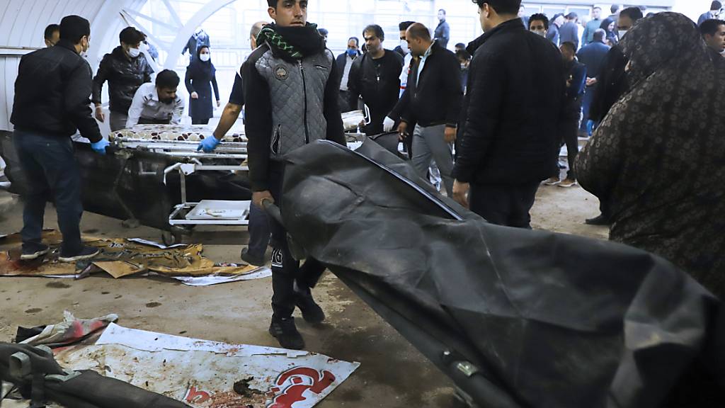 dpatopbilder - Ein Mann trägt die Leiche eines Opfers in einem Leichensack nach zwei Explosionen in der Stadt Kerman, etwa 510 Meilen (820 Kilometer) südöstlich der Hauptstadt Teheran. Die Terrormiliz Islamischer Staat (IS) hat den verheerenden Anschlag mit mehr als 80 Toten für sich reklamiert. Foto: Sare Tajalli/Iranian Students' News Agency, ISNA/dpa