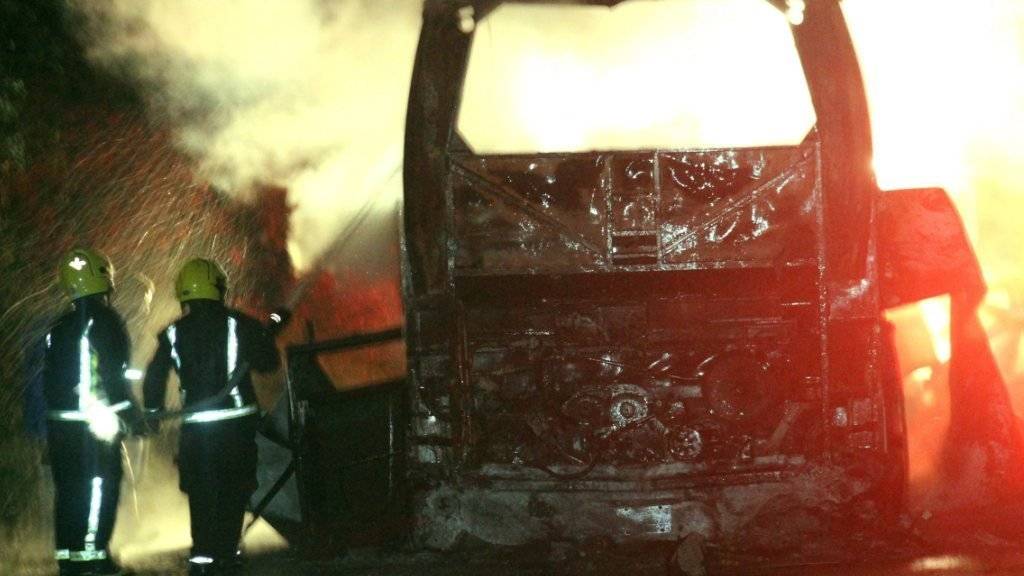 Mexikanische Feuerwehrleute versuchen den in Brand geratenen Reisebus zu löschen. Bei dem Unglück kamen mindestens 20 Menschen ums Leben.
