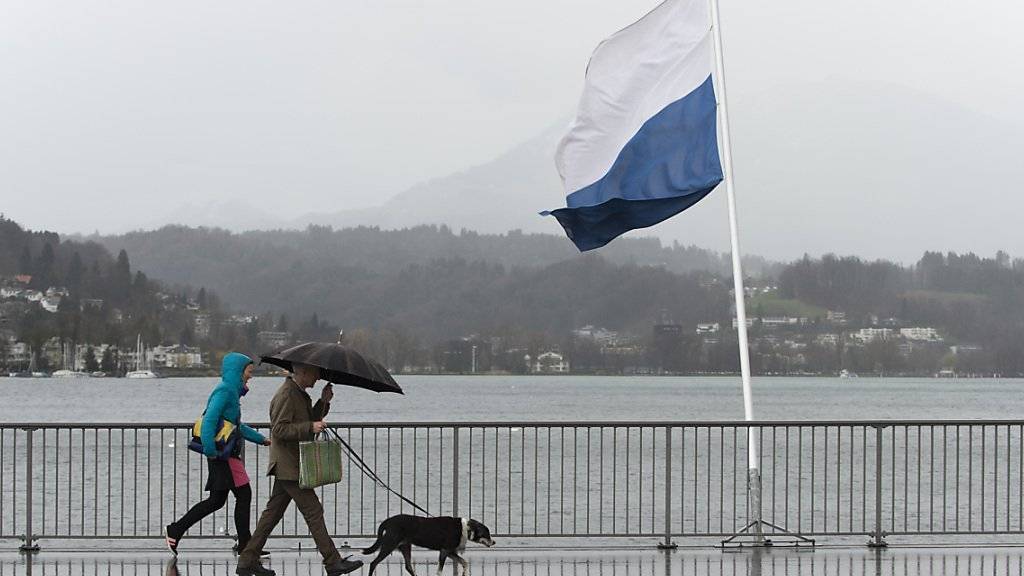 Nach dem Hundewetter mit Sturm und Regen erwarten Meteorologen den Winter in der Schweiz. Im Bild Spaziergänger am Vierwaldstättersee. (Archivbild)