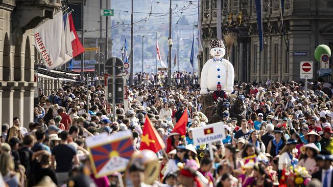 Mädchen und Buben marschieren in Trachten durch Zürich 