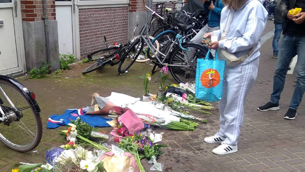 Eine Frau steht vor Blumen am Tatort, nachdem dort am Abend des 6. Juli der niederländische Journalist de Vries niedergeschossen wurde. Foto: Molly Quell/AP/dpa