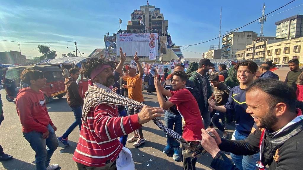 Anti-Regierungs-Demonstranten tanzen auf dem Tahrir-Platz in Bagdad.