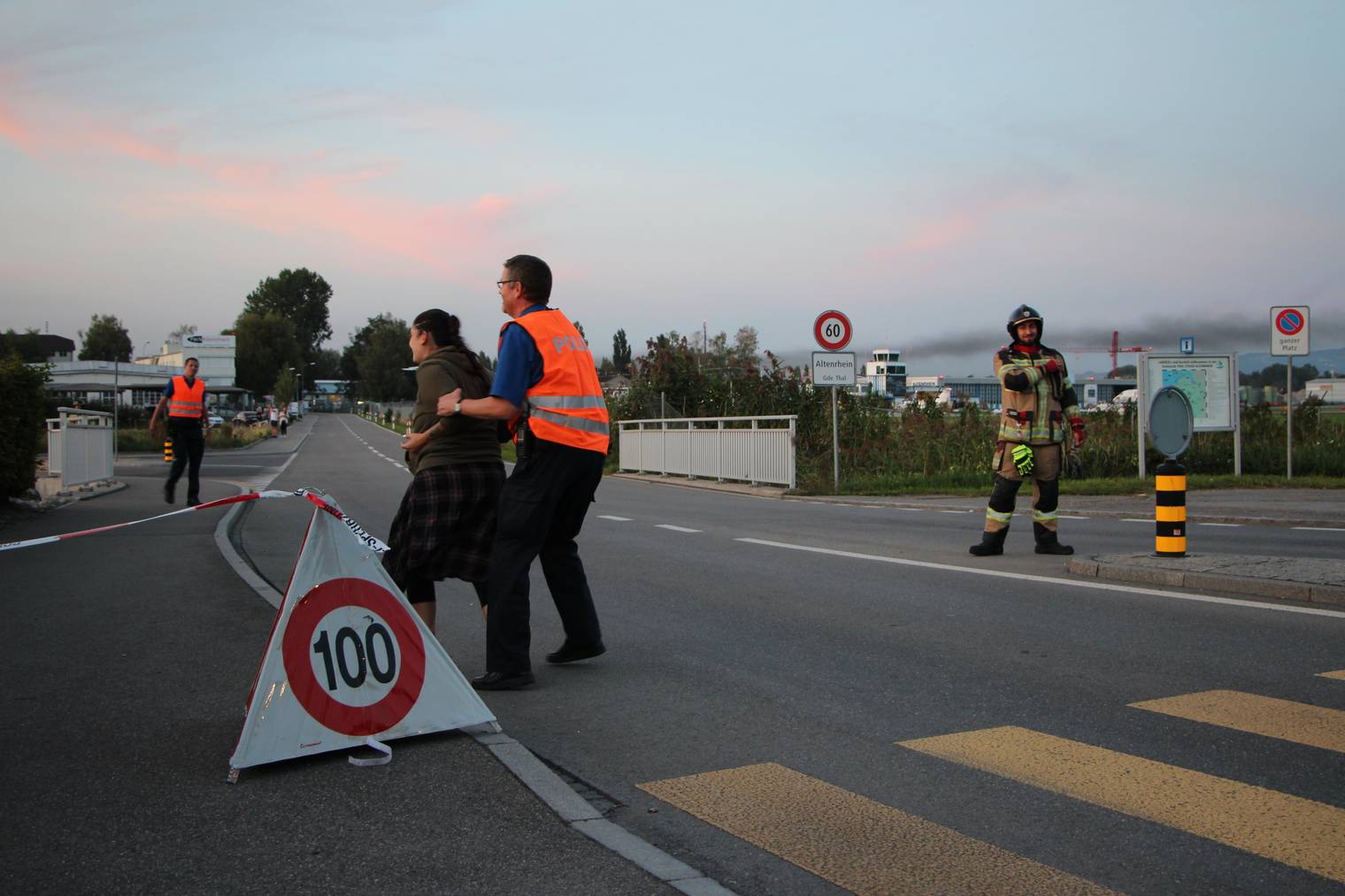 Die Frau versucht sich immer wieder Zutritt zum Flughafengelände zu verschaffen. Sie muss von Polizisten festgehalten werden. (Bild: FM1Today)