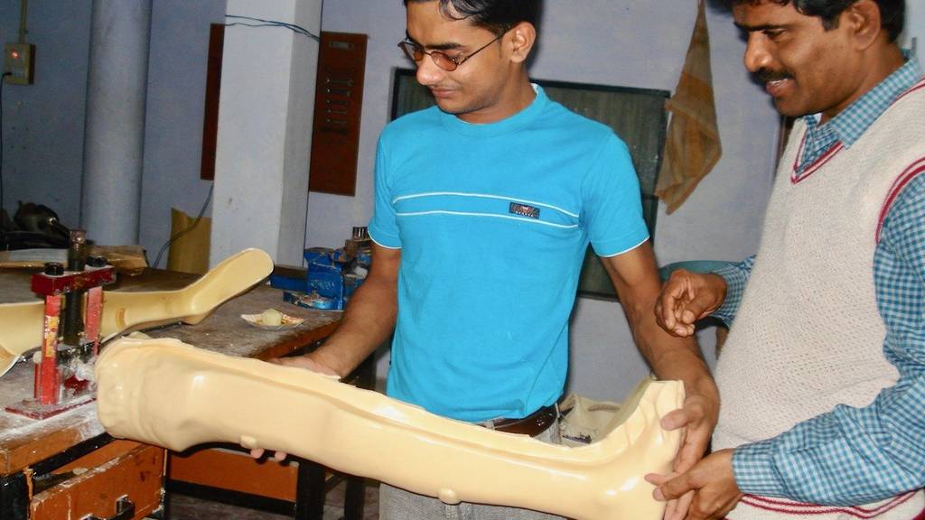 Mitarbeiter von Kiran stellen eine Prothese her.