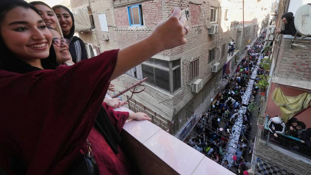 ARCHIV - Ägyptische Mädchen posieren für ein Selfie während eines «Iftar» während des heiligen Fastenmonats Ramadan in Ezbet Hamada im Kairoer Stadtteil El Matareya. Foto: Amr Nabil/AP/dpa (Archivbild)