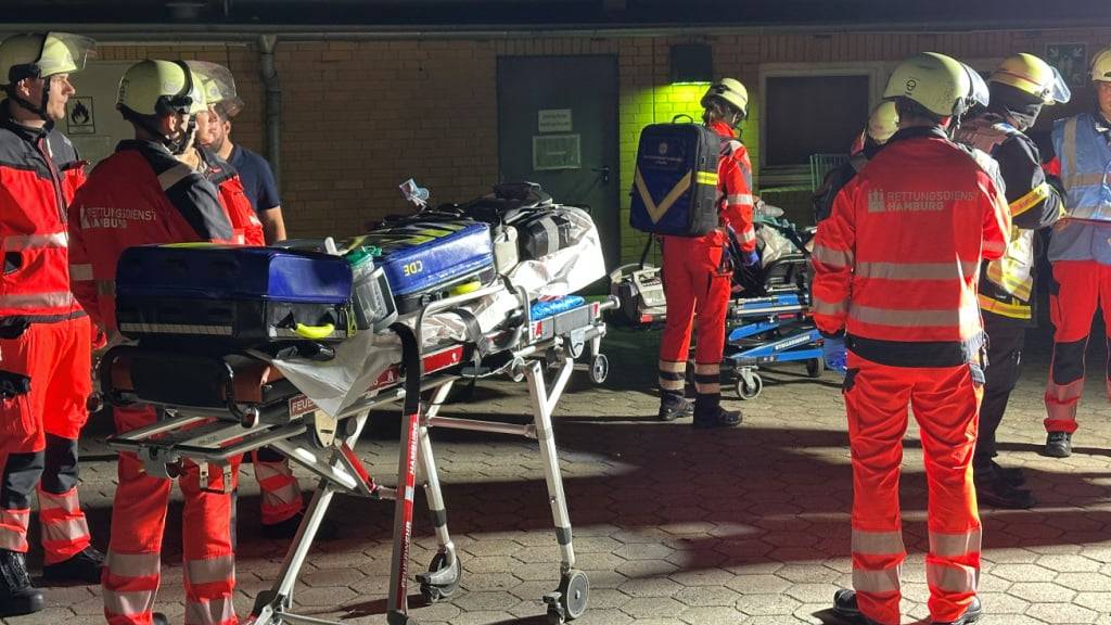 Sanitäter des Rettungsdienstes der Hambuger Feuerwehr warten auf ihren Einsatz am Marienkrankenhaus im Hamburger Stadtteil Hohenfelde. Die Flammen seien von der Geriatrie im Erdgeschoss der Klinik auf das erste Obergeschoss übergeschlagen. Feuerwehrleute versuchten Menschen über Fenster ins Freie zu retten. Foto: Steven Hutchings/dpa