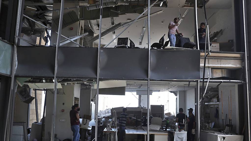 Anwohner stehen in einem Gebäude, das durch die massive Explosion im Hafen von Beirut stark beschädigt wurde. Auch eine Diplomatin der deutschen Botschaft ist unter den mehr als 130 Toten. Foto: Bilal Hussein/AP/dpa