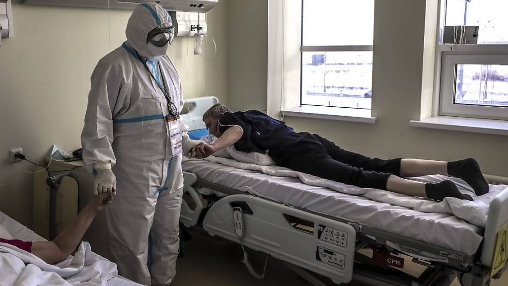 Der Bischof (M) der Russisch-Orthodoxen Kirche, Panteleimon, tröstet Patienten, die im Verdacht stehen, das Coronavirus zu haben, in einem Krankenhaus in Kommunarka, außerhalb von Moskau. Foto: Sophia Sandurskaya/Moscow News Agency/dpa