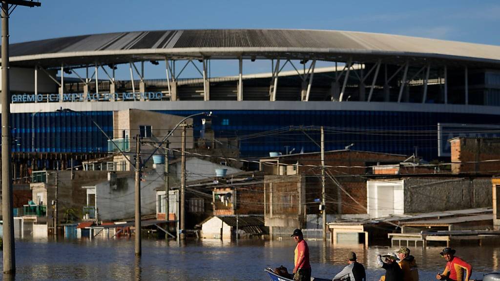 dpatopbilder - Anwohner fahren in Porto Alegre im brasilianischen Bundesstaat Rio Grande do Sul an der Gremio-Arena vorbei, die von den Wassermassen der schweren Regenfälle überflutet ist. Foto: Andre Penner/AP/dpa