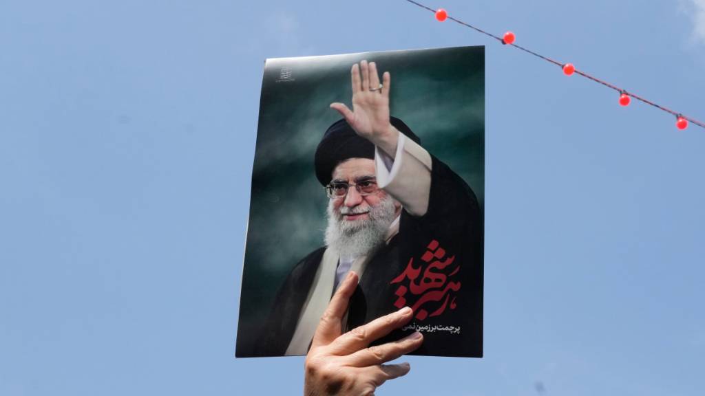 ARCHIV - Eine Frau hält ein Poster des verstorbenen iranischen Obersten Führers Ajatollah Ali Chamenei in die Höhe. Foto: Vahid Salemi/AP/dpa/Archivbild