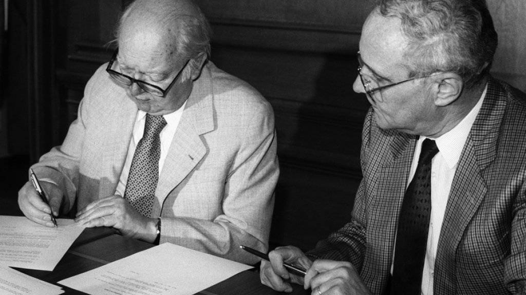 Friedrich Dürrenmatt (l) und der damalige Bundesrat Flavio Cotti unterzeichneten am 28. Juni 1989 in Bern den Erbvertrag, der die Gründung des Schweizerischen Literaturarchivs (SLA) besiegelte. Dieser Tage feiert das Institut seinen 25. Geburtstag (Archiv).