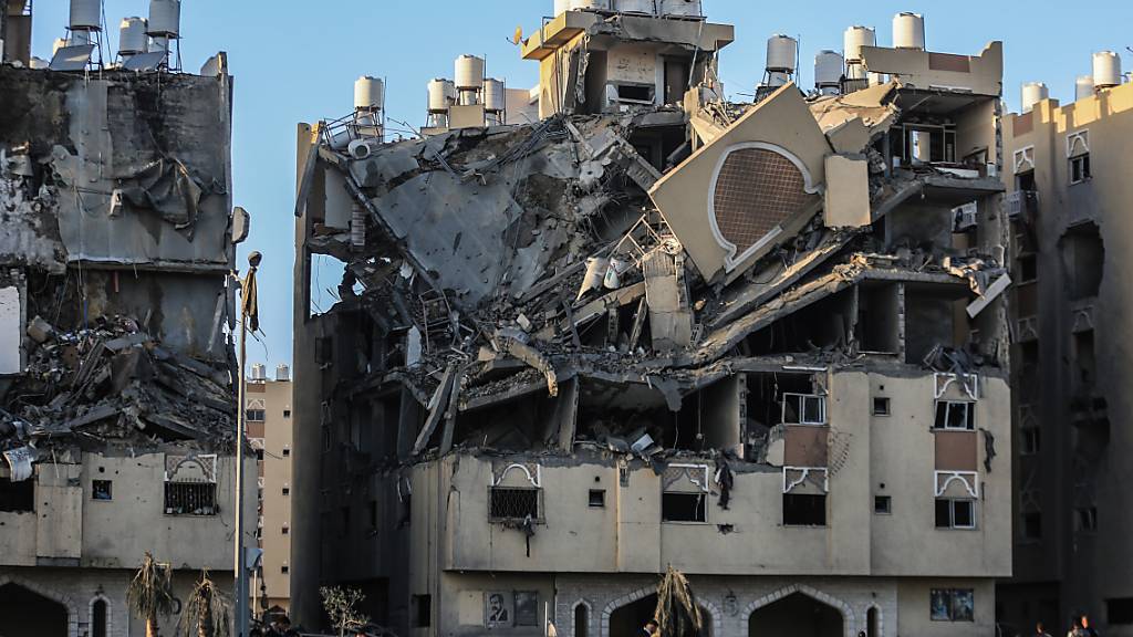 Bewohner des von Katar finanzierten Wohnkomplexes Hamad Town tragen während der Flucht aus ihren Häusern einige Habseligkeiten, nachdem bei einem israelischen Angriff mehr als sechs Wohntürme vollständig zerstört wurden. Foto: Mohammed Talatene/dpa