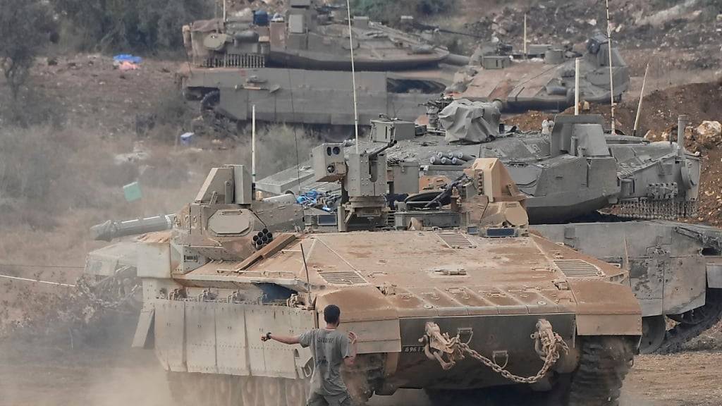 Israelische gepanzerte Mannschaftstransportwagen (APC) und Panzer manövrieren in einem Bereitstellungsraum im Norden Israels nahe der israelisch-libanesischen Grenze. Foto: Baz Ratner/AP/dpa