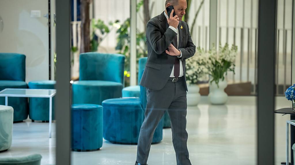 Bundeskanzler Olaf Scholz (SPD), telefoniert in einem Nebenraum beim Westbalkan-Gipfel während der Arbeitssitzung. Foto: Michael Kappeler/dpa