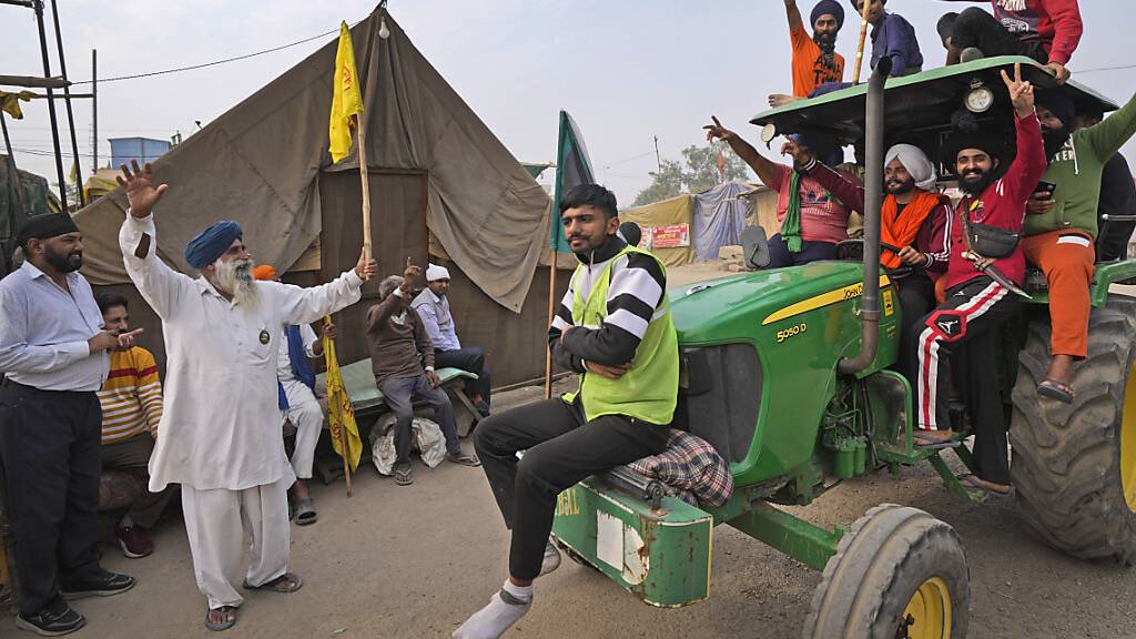 Landwirte feiern die Nachricht von der Aufhebung der Landwirtschaftsgesetze, gegen die sie protestiert hatten. Premierminister Narendra Modi teilte am Freitag mit, dass nach fast einjährigen Protesten die kontroverse Agrarmarktreform zurückgezogen werden soll. Foto: Manish Swarup/AP/dpa