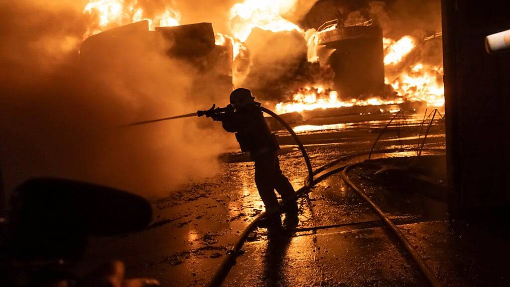 Feuerwehrleute löschen ein Feuer nach einem russischen Angriff auf ein Wohnviertel. Foto: Yevhen Titov/AP/dpa